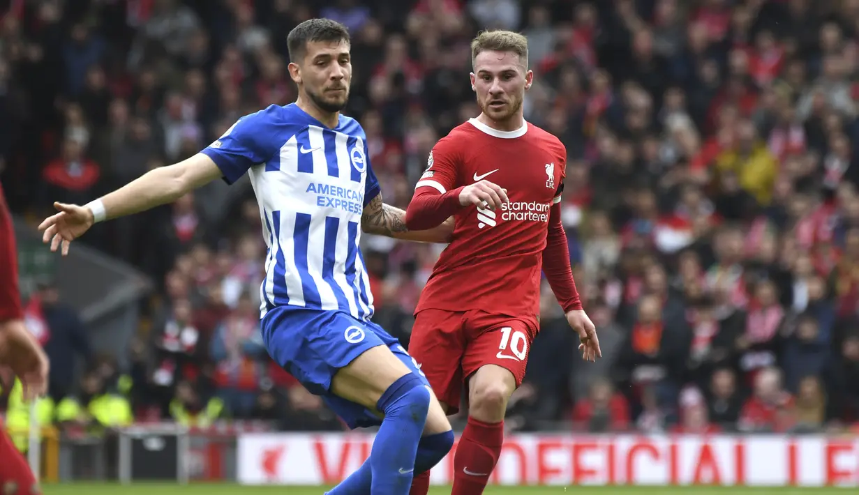 Gelandang Liverpool, Alexis Mac Allister (kanan) melepaskan umpan di depan gelandang Brighton and Hove Albion, Jakub Moder pada laga pekan ke-30 Premier League 2023/2024 di Anfield Stadium, Liverpool, Minggu (31/3/2024). (AP Photo/Rui Viera)