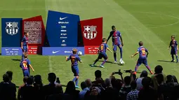Penyerang baru Barcelona, Ousmane Dembele bermain bola dengan anak-anak saat perkenalan dirinya di Stadion Camp Nou, Barcelona, Spanyol, (28/8). Pemain asal Prancis ini dikontrak Barcelona sekitar 147 juta euro. (AP Photo / Manu Fernandez)