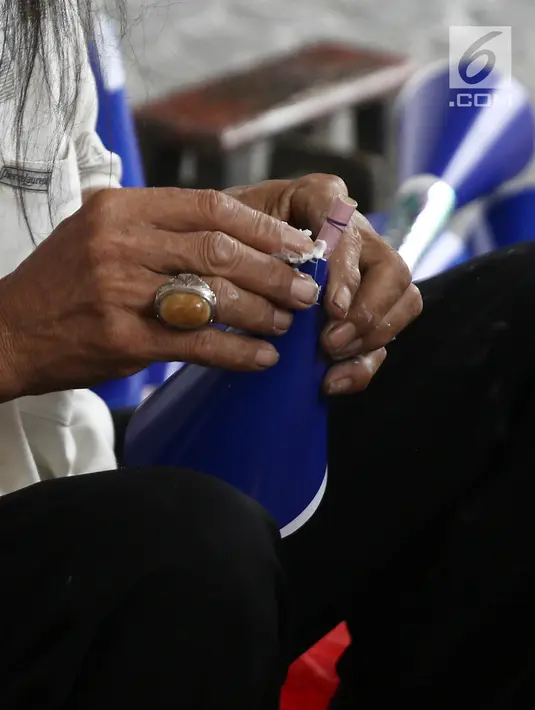 Pengrajin menyelesaikan pembuatan terompet di kawasan Glodok, Jakarta, Selasa (25/12). Menjelang tahun baru terompet konvensional tersebut dijual dengan harga dari Rp 5000 hingga Rp 10.000 tergantung ukuran dan jenisnya. (Liputan6.com/Herman Zakharia)