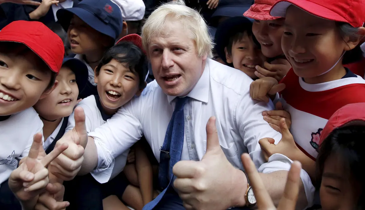 Boris Johnson (tengah) berfoto dengan anak - anak setelah bermain rugby di sebuah lapangan mini, Tokyo, Jepang,  Kamis (15/10/2015).  Acara ini juga dihadiri oleh para organisasi masyarakat dan perwakilan dari rugby Jepang. (REUTERS/Issei Kato) 