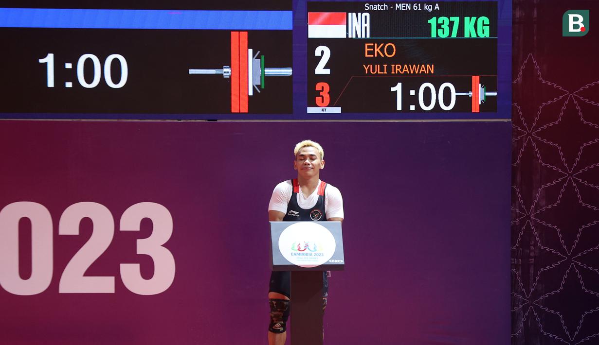 <p>Atlet angkat besi Indonesia, Eko Yuli Irawan berkompetisi pada nomor angkat besi putra 61 kg SEA Games 2023 di Taekwondo Hall Olympic Complex, Phnom Penh, Kamboja, Sabtu (13/05/2023). (Bola.com/Abdul Aziz)</p>
