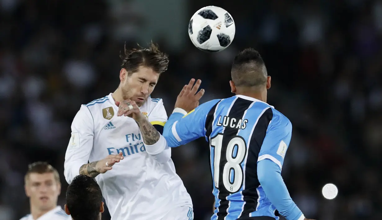 Bek Real Madrid, Sergio Ramos, duel udara dengan pemain Gremio, Lucas Barrios, pada final Piala Dunia Antarklub di Stadion Syeikh Zayed, Abu Dhabi, Sabtu (16/12/2017). Real Madrid menang 1-0 atas Gremio. (AP/Hassan Ammar)
