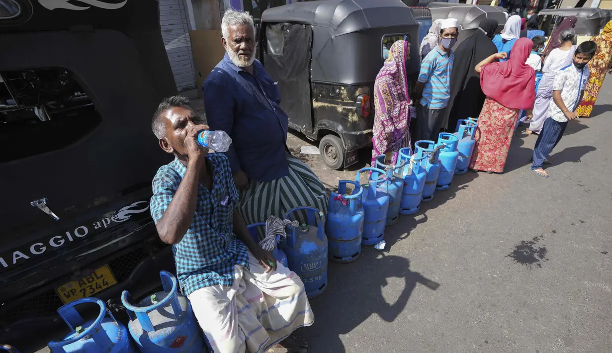 Warga Sri Lanka mengantre untuk mengisi ulang tabung gas memasak saat terjadi kekurangan pasokan di KolomboSelasa (4/1/2022). Antrean panjang selama berjam-jam telah menjadi pemandangan biasa dalam beberapa hari terakhir dalam upaya untuk membeli tabung gas domestik. (AP Photo/Eranga Jayawardena).