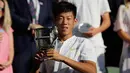 Petenis Taiwan Tseng Chun Hsin berpose dengan trofi usai mengalahkan Jack Draper dari Inggris di final tunggal putra Kejuaraan Tenis Wimbledon Junior di London, (15/7). Petenis 16 tahun ini menang dengan skor 6-1, 6-7 (2/7), dan 6-4. (AP Photo/Ben Curtis)
