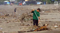 Seorang sukarelawan membersihkan sampah di kawasan Pantai Citepus, Pelabuhan Ratu, Sukabumi, Jumat (4/1). Kegiatan aksi Jumsih (Jumat Bersih) setiap minggunya ini sudah berlangsung sejak tahun 2002. (Merdeka.com/Arie Basuki)