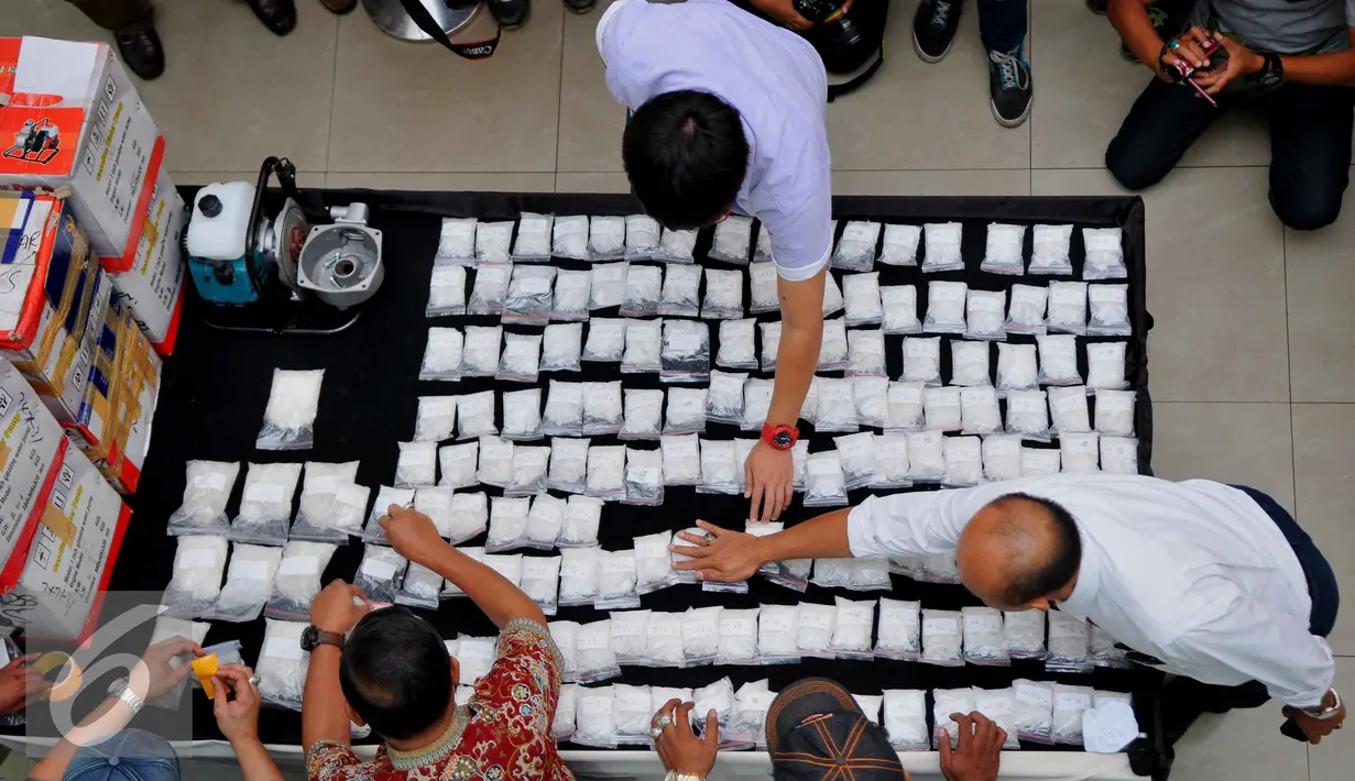 Petugas memperlihatkan barang bukti jenis sabu 15,5 Kg yang berhasil diamankan Polisi dari tersangka Warga negara Nigeria, Jakarta, Jumat (6/3/2015). Modus yang dilakukan dalam sindikat tersebut melalui mesin pompa air. (Liputan6.com/Gempur M Surya)