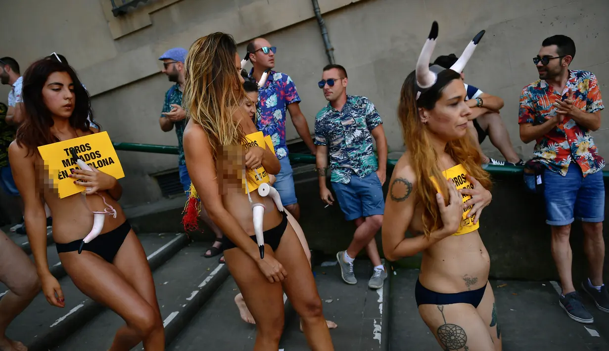Aktivis yang bertelanjang dada menyusuri jalanan saat menggelar protes terhadap adu banteng di Pamplona, Spanyol, Jumat (5/7/2019). Aksi protes ini digelar sehari sebelum pembukaan Festival San Fermin. (AP Photo/Alvaro Barrientos)