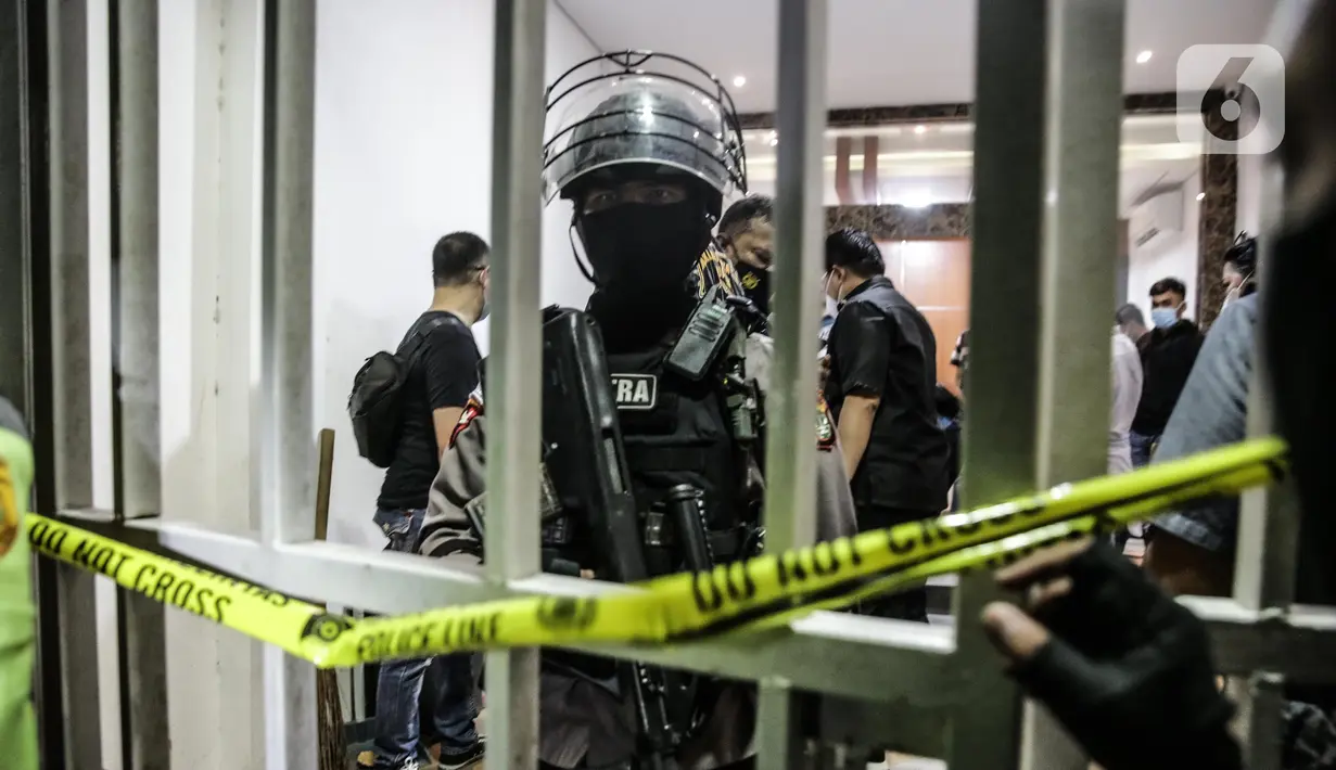Polisi berjaga saat penggeledahan di lokasi bekas Sekretariat Markas Front Pembela Islam di Petamburan, Jakarta, Selasa (27/4/2021). Munarman juga diduga menyembunyikan informasi tentang tindak pidana terorisme. (Liputan6.com/Faizal Fanani)