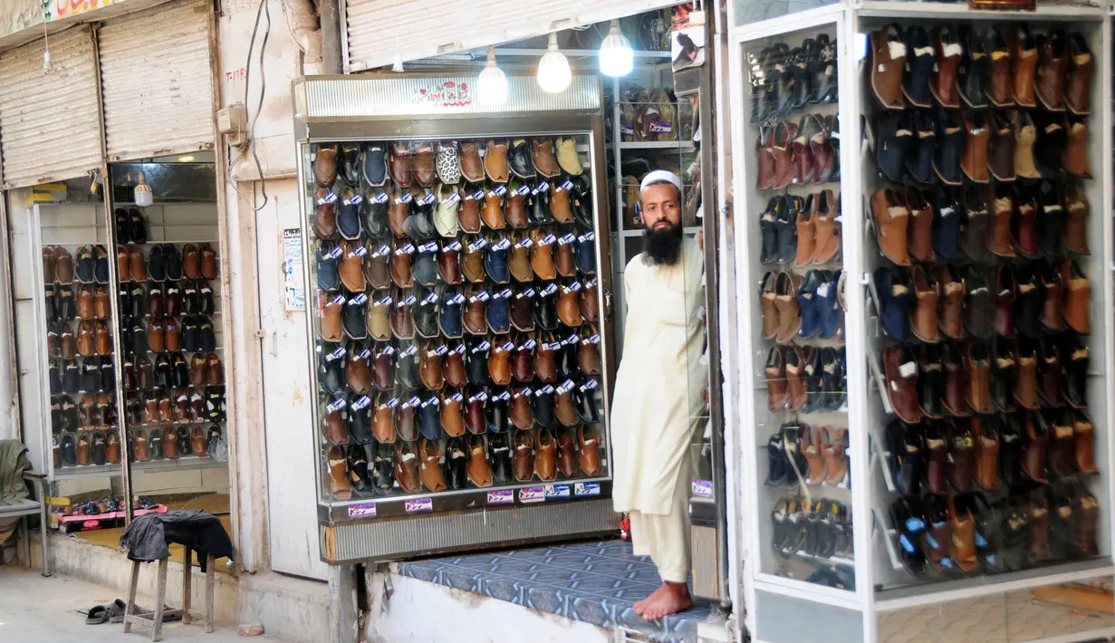 Seorang pedagang asal Pakistan menjual sepatu tradisional yang dikenal sebagai "chapli" di kalangan penduduk lokal untuk menyambut Hari Raya Idul Fitri di Peshawar, Pakistan barat laut, pada 19 Mei 2020. (Xinhua/Saeed Ahmad)