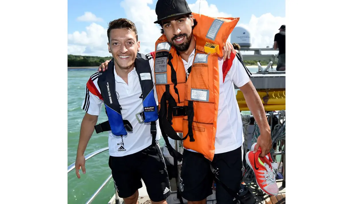 Dua gelandang Timnas Jerman, Mesut Ozil (kiri) berpose bersama Sami Khedira di atas kapal saat berlayar di salah satu pantai dekat Santo Andre, Sao Paolo, Brasil, (10/6/2014). (AFP PHOTO/Markus Gilliar)