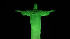 Patung Kristus Penebus raksasa yang terkenal di Rio de Janeiro, Brasil, diterangi dengan lampu hijau pada kesempatan Hari Lingkungan Hidup Sedunia pada Senin (5/6/2023). (CARL DE SOUZA / AFP)