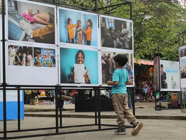 Pengunjung menyaksikan karya foto jurnalistik dalam pameran Haluan Merah Putih Roadshow yang digelar di Selasar Kantin Taman Margasatwa Ragunan, Jakarta Selatan, Rabu (24/12/2025). Kantor Berita Nasional (LKBN) ANTARA bekerja sama dengan Taman Margasatwa Ragunan menghadirkan pameran hasil karya jurnalistik. (merdeka.com/magang/Rendi Saputra)