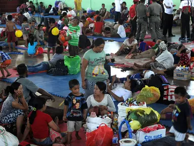 Penduduk desa beristirahat setelah dievakuasi di tempat penampungan sementara di Kabupaten Klungkung, Bali (22/9). Para penduduk desa dievakuasi sehubungan meningkatnya aktivitas Gunung Agung. (AFP Photo/Sonny Tumbelaka)