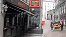Staf memindahkan meja luar ruangan dari sebuah pub menyusul pemberlakuan lockdown setelah jumlah kasus virus corona melonjak di Skotlandia, Kamis (6/8/2020). Pemerintah Kota Aberdeen mencatat puluhan kasus virus korona baru dalam minggu ini. (Michal Wachucik / POOL / AFP)