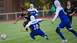 Pesepakbola wanita Iran berusaha merebut bola yang di bawa pemain wanita Jerman pada pertandingan Discover Football tournament di Berlin, Jerman (31/8). Tampil mengunakan hijab pesepakbola wanita Iran jadi pusat perhatian penonton.(REUTERS/Stefanie Loos)
