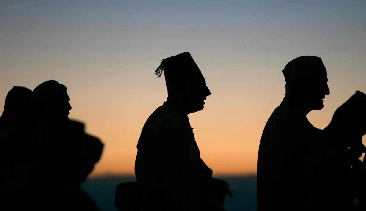 Siluet kaum Samaritan saat berdoa di puncak Gunung Gerizim, Israel (4/10). Orang Samaritan atau Samaria adalah sebuah komunitas yang terdiri dari beberapa ratus orang yang tinggal di Israel dan di daerah Nablus. (AFP Photo/Jaafar Ashtiyeh)