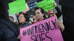 Sejumlah orang menggelar aksi protes kepada United Airlines di Bandara Internasional O'Hare, Chicago, AS, Selasa (11/4). Demonstran mengecam tindakan polisi yang mengeluarkan penumpang tidak manusiawi). (Scott Olson / Getty Images / AFP)