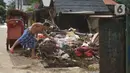 Warga membersihkan sampah setelah banjir merendam kawasan Cipinang Muara, Jakarta, Rabu (26/2/2020). Banjir dari luapan Sungai Kalimalang tersebut menyebabkan warga harus bekerja ekstra untuk membersihkan perabotan serta lumpur dan sampah. (Liputan6.com/Immanuel Antonius)