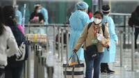 Penumpang yang tiba langsung dari Manila untuk bus ke hotel karantina di bandara internasional Hong Kong, Jumat (1/4/2022). Hong Kong mencabut larangan terhadap kedatangan dari sembilan negara termasuk Australia, Kanada, Prancis, India, Nepal, Pakistan, Filipina, Inggris, dan AS. (AP Photo/Kin Cheun