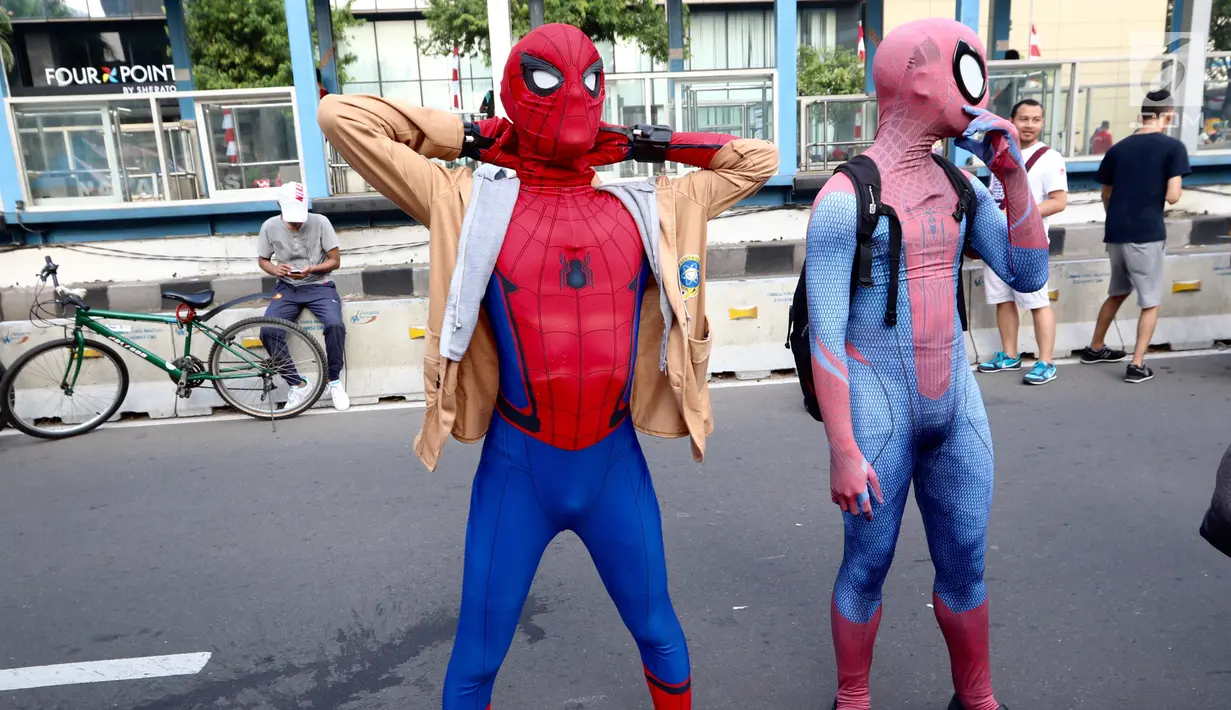Dua orang dengan kostum Spiderman bergaya saat menunggu warga untuk berswafoto di CFD Jalan MH Thamrin, Jakarta, Minggu (6/8). Mereka mengajak warga berswafoto sambil berdonasi untuk panti asuhan. (Liputan6.com/Fery Pradolo)