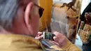 Seorang pria mengambil gambar cokelat badak di toko cokelat Eric Thevenot di Nogent-sur-Marne, Prancis (8/4). Cokelat ini dipersembahkan untuk badak yang dibunuh di kebun binatang Thoiry. (AFP/Geoffroy Van Der Hasselt)