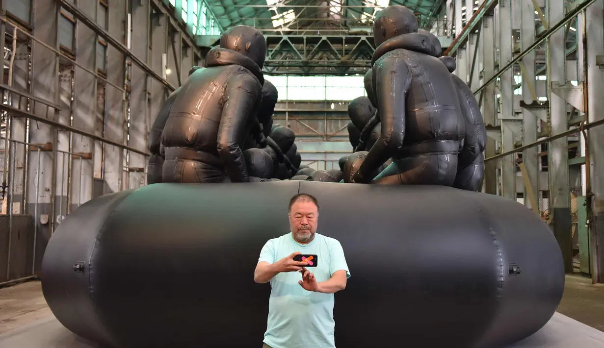 Seniman asal China, Ai Weiwei berselfie di depan karyanya yang berjudul "Law of the Journey 2017"di preview pers Biennale ke 21 di Sydney (12/3). Biennale akan berlangsung mulai 16 Maret - 11 Juni 2018. (AFP Photo/Peter Parks)