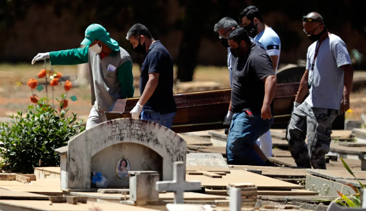 Petugas membawa peti jenazah berisi Elvira Maria de Jesus (75), yang dikatakan meninggal karena COVID-19, di pemakaman Campo da Esperanca di Brasilia, Brasil, Kamis (3//9/2020). Brasil melaporkan rata-rata lebih dari 1.000 kematian setiap hari akibat corona sejak akhir Mei. (AP Photo/Eraldo Peres)