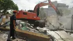 Petugas mengamati alat berat yang sedang meratakan rumah dinas para pensiunan PT KAI di Jalan Bungur Besar, Kompleks PJKA, Senen, Jakarta, Kamis (14/4). Tanah seluas 60.930 m2 itu akan digunakan untuk parkir kereta. (Liputan6.com/Gempur M Surya)