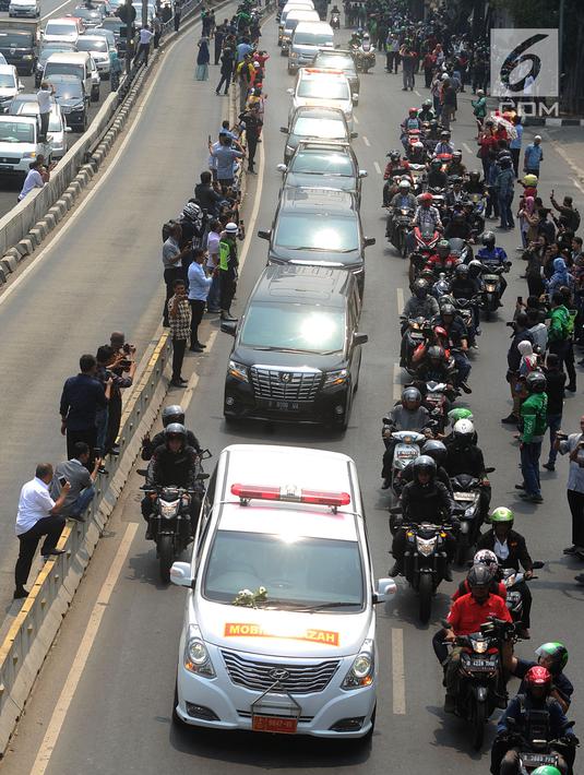 Iring-iringan mobil jenazah yang membawa almarhum Presiden ke-3 RI, BJ Habibie melintasi Jalan Gatot Subroto menuju TMP Kalibata, Jakarta, Kamis (12/9/2019). Warga secara khusus meluangkan waktu menyambut jenazah BJ Habibie untuk memberikan penghormatan terakhir. (merdeka.com/Arie Basuki)