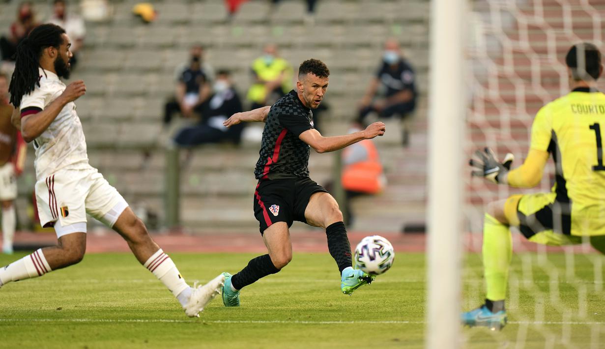 Striker Kroasia, Ivan Perisic (tengah) melepaskan tendangan ke gawang Belgia dalam laga uji coba menjelang berlangsungnya Euro 2020 di King Baudouin Stadium, Brussels, Minggu (6/6/2021). Kroasia kalah 0-1 dari Belgia. (AP/Francisco Seco)