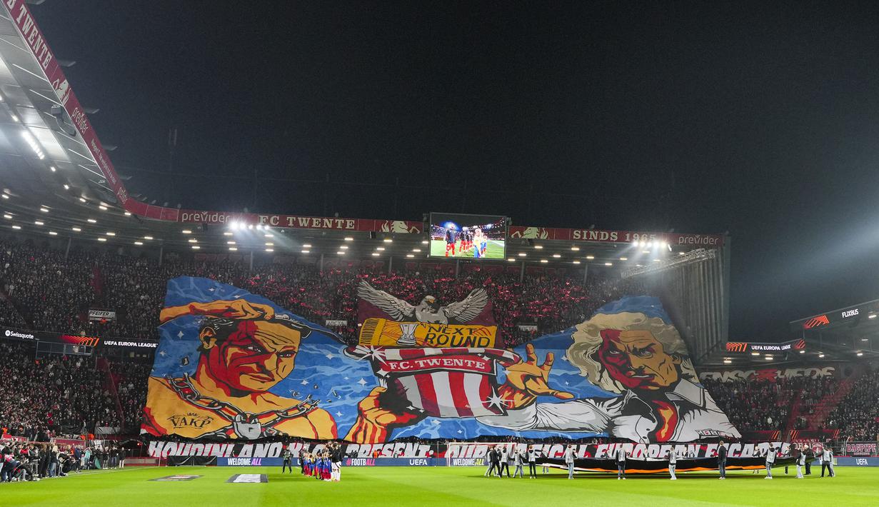 Pendukung FC Twente membentangkan koreografi dalam laga lanjutan Liga Europa 2024/2025 melawan Besiktas di De Grolsch Veste stadium, Enschede, Belanda, Jumat (31/01/2025) dini hari WIB. (AP Photo/Peter Dejong)
