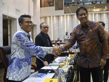 Menteri Keuangan Purbaya Yudhi Sadewa (kanan) berjabat tangan dengan Ketua Komisi XI DPR RI Mukhamad Misbakhun (kiri) sebelum mengikuti rapat kerja di Kompleks Parlemen, Senayan, Jakarta, Rabu (10/9/2025). (merdeka.com/Arie Basuki)