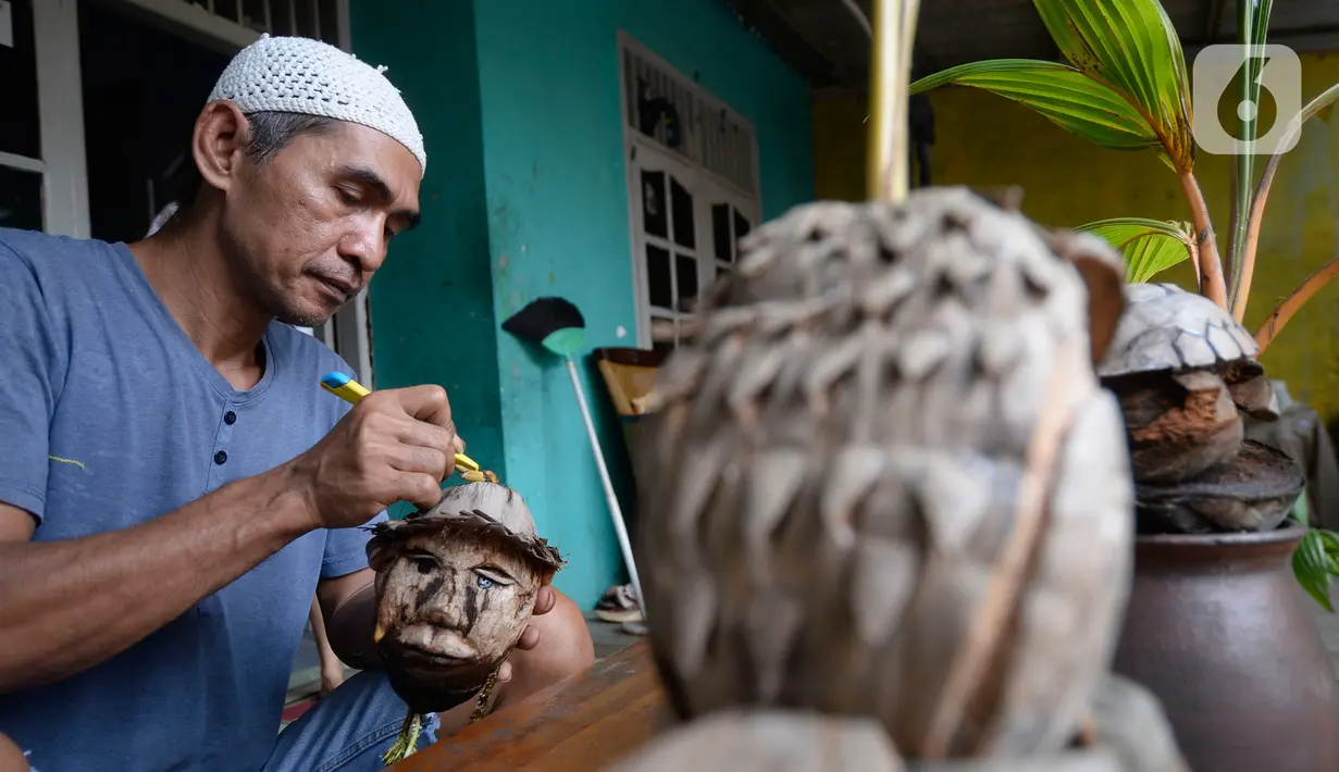 Seniman, Herman Ronda (49) mengukir bibit pohon kelapa yang dijadikan bonsai di Pondok Benda Pamulang, Tangerang Selatan, Selasa (13/10/2020). Budidaya bonsai tanaman kelapa semakin digemari untuk memanfaatkan waktu dengan harga mulai dari Rp 250 ribu hingga Rp 500 ribu. (merdeka.com/Dwi Narwoko)