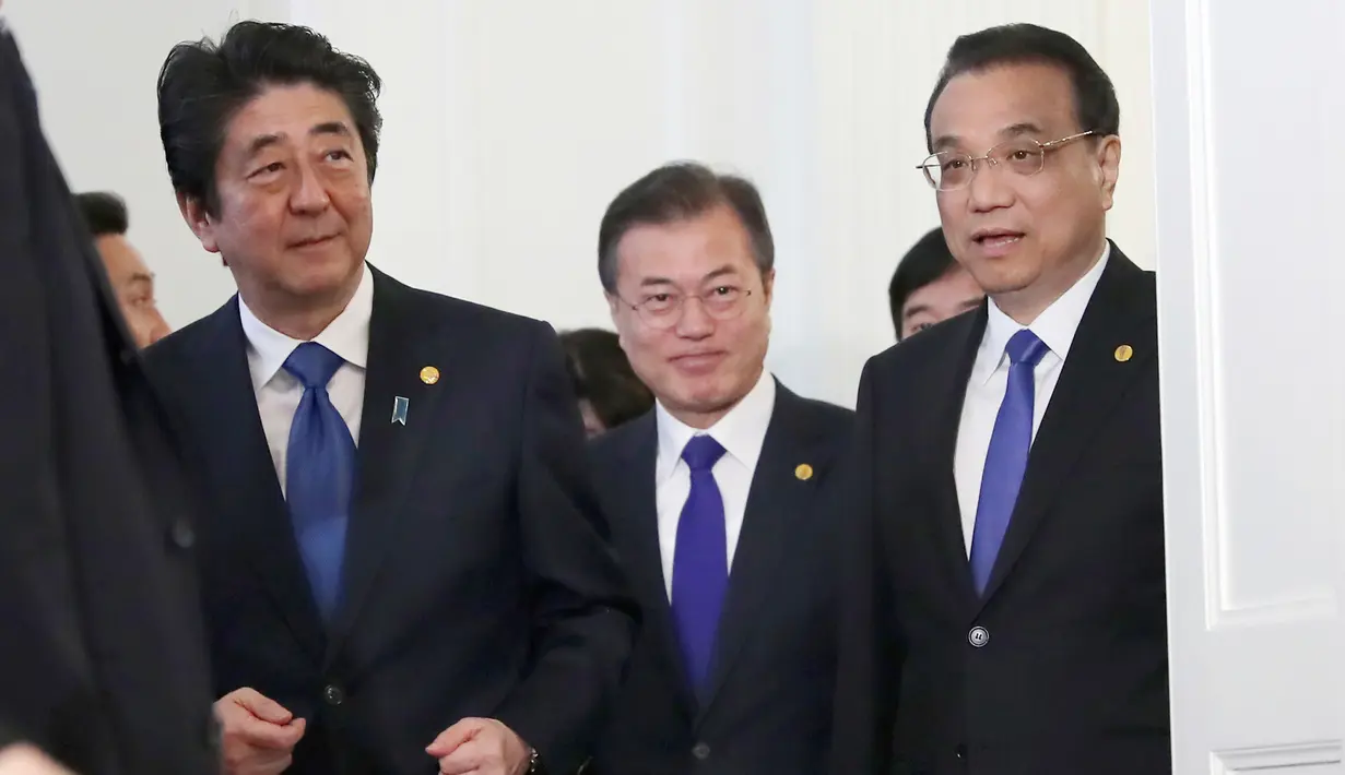 Perdana Menteri Jepang Shinzo Abe, Presiden Korea Selatan Moon Jae-in, Perdana Menteri China Li Keqiang berjalan bersama usai melakukan pertemuan tingga negara di Tokyo, Jepang (9/5). (AP Photo/Eugene Hoshiko, Pool)
