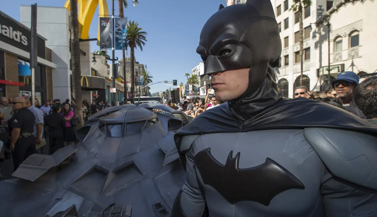Pria berpakaian Batman berpose depan Batmobil terbaru dalam serial film " Batman v Superman : Dawn of Justice " di Los Angeles, California, (21/10/2015).  Acara Ini merupakan penghargaan terhadap pencipta Batman Bob Kane. (REUTERS/Mario Anzuoni)