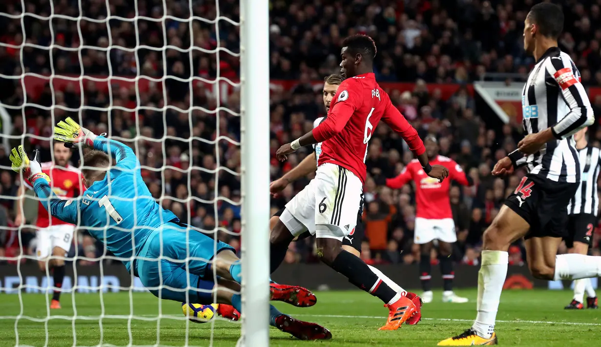 Pemain Manchester United, Paul Pogba (tengah) berhasil mencetak gol ke gawang Newcastle United pada laga lanjutan Premier League pekan ke-12 di Old Trafford, Minggu (19/11). MU menang telak 4-1 atas Newcastle. (Martin Rickett/PA via AP)