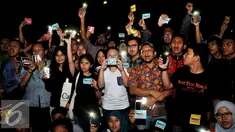 Sejumlah aktivis menyalakan senter saat melakukan aksi solidaritas #MelawanGelap di depan Istana Merdeka, Jakarta, Jumat (5/8). Aksi tersebut merupakan bentuk dukungan kepada Koordinator Kontras Haris Azhar. (Liputan6.com/Gempur M Surya)