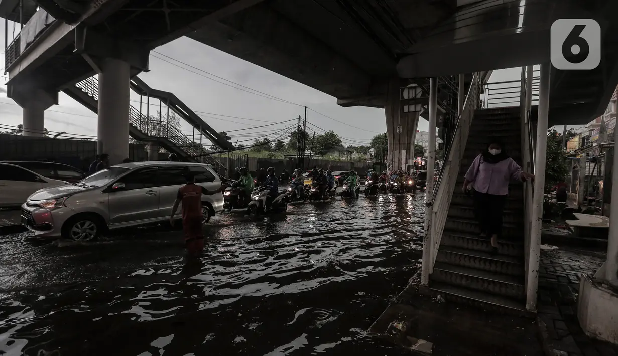 Sejumlah kendaraan menerobos Banjir yang menggenangi kawasan Seskoal - Cipulir, Jakarta, Selasa (4/4/2022). Hujan yang mengguyur wilayah Ibu Kota Jakarta mengakibatkan banjir menggenangi kawasan Simpang Seskoal, Kebayoran Lama, Jakarta. Banjir setinggi 50cm - 1 meter disebabkan saluran pembuangan berukuran kecil tersumbat. (Liputan6.com/Johan Tallo)