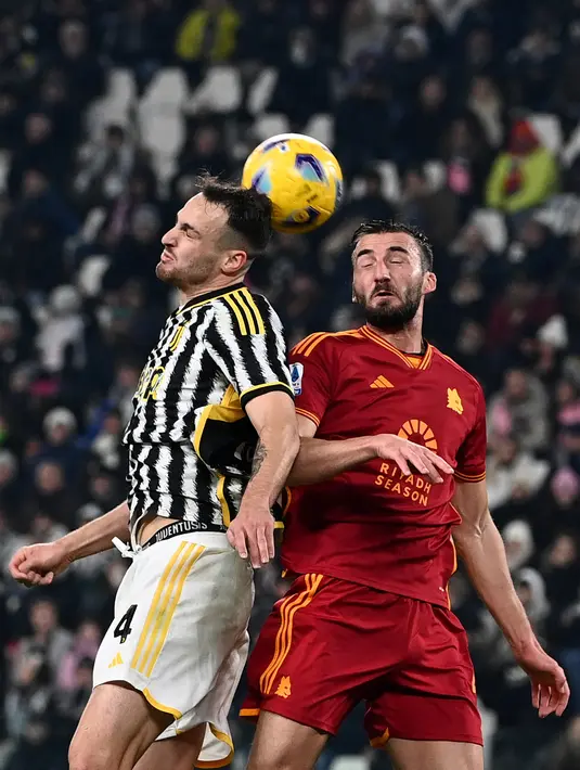Gelandang AS Roma #04 Bryan Cristante (kanan) berebut bola dengan bek Juventus #04 Federico Gatti pada duel pekan ke-18 Serie A 2023/2024 di Allianz Stadium, Minggu (31/12/2023) dini hari WIB. (sabella BONOTTO / AFP)