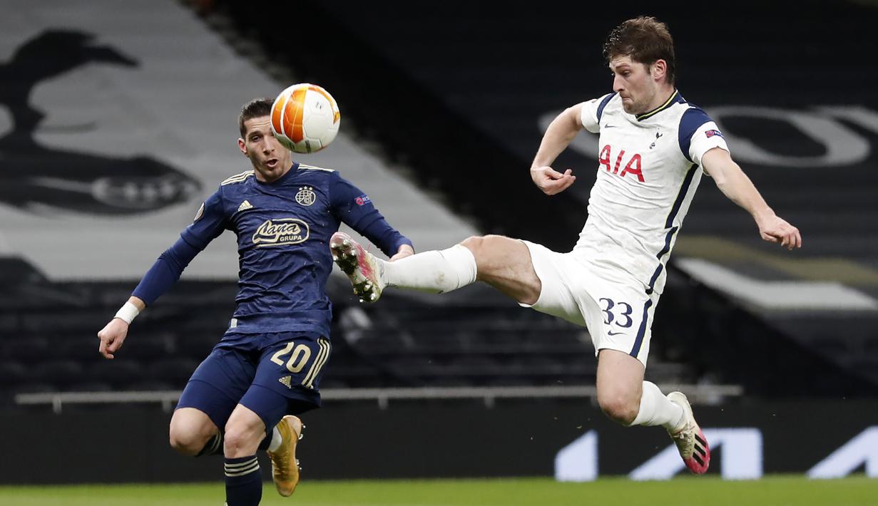Bek Tottenham Hotspur, Ben Davies membuang bola dari ancaman striker Dinamo Zagreb, Lirim Kastrati dalam laga leg pertama babak 16 besar Liga Europa 2020/2021 di Tottenham Hotspur Stadium, London, Kamis (11/3/2021). Tottenham menang 2-0 atas Dinamo Zagreb. (AP/Alastair Grant/Pool)