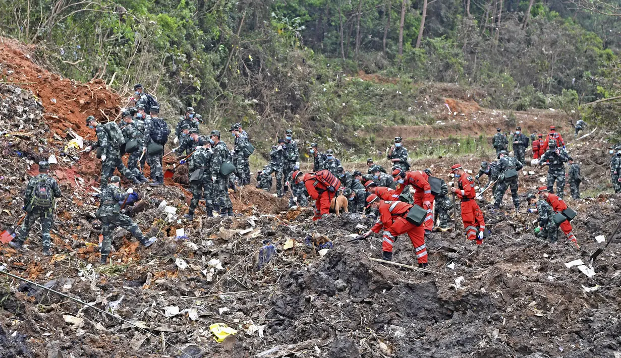 Petugas penyelamat mencari kotak hitam di lokasi kecelakaan pesawat di daerah Tengxian, Daerah Otonomi Guangxi Zhuang, China barat daya (22/3/2022). Pesawat Boeing 737-800 milik China Eastern Airlines yang mengangkut 132 orang jatuh di pegunungan Guangx pada 21 Maret 2022. (Zhou Hua/Xinhua via AP)