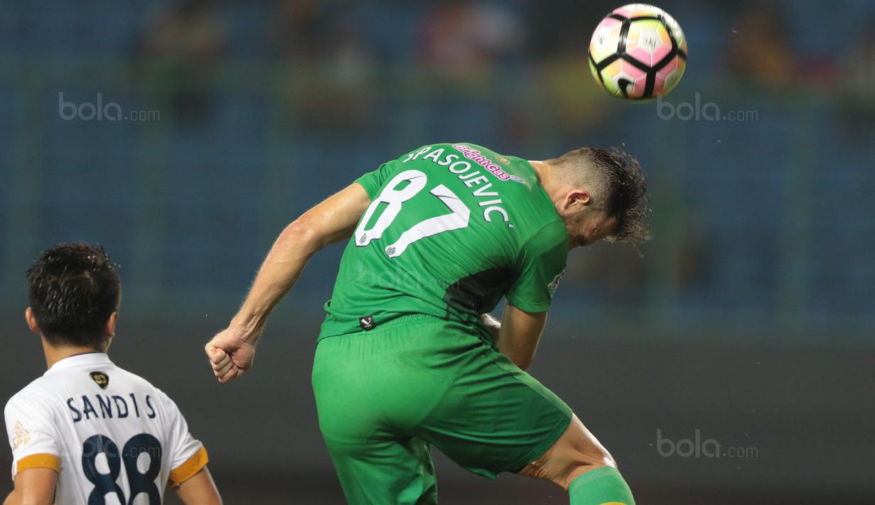 Aksi penyerang Bhayangkara FC, Ilija Spasojevic (kanan) membuang bola dari kejaran pemain Persela Lamongan, Sandi pada lanjutan Liga 1 2017 di Stadion Patriot, Bekasi, (27/10/2017). Bhayangkara menang 3-1. (Bola.com/Nicklas Hanoatubun)