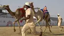 Para pawang berlari bersama unta mereka pada awal perlombaan Festival Unta Putra Mahkota di Kota Taif, Arab Saudi, Rabu (11/8/2021). Selain mempromosikan warisan balap unta Arab Saudi, festival ini juga berupaya untuk mendukung pariwisata dan pembangunan ekonomi. (Amer HILABI/AFP)