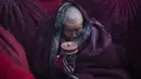 Seorang Biksu berdoa dengan memakai jubah di dekat Larung Wuming Buddha Institute, Tibet, Cina (1/11/2015). Larung Wuming Buddha Institute menjadi salah satu pusat terbesar untuk mempelajari agama Buddha Tibet di dunia. (REUTERS/Damir Sagolj)