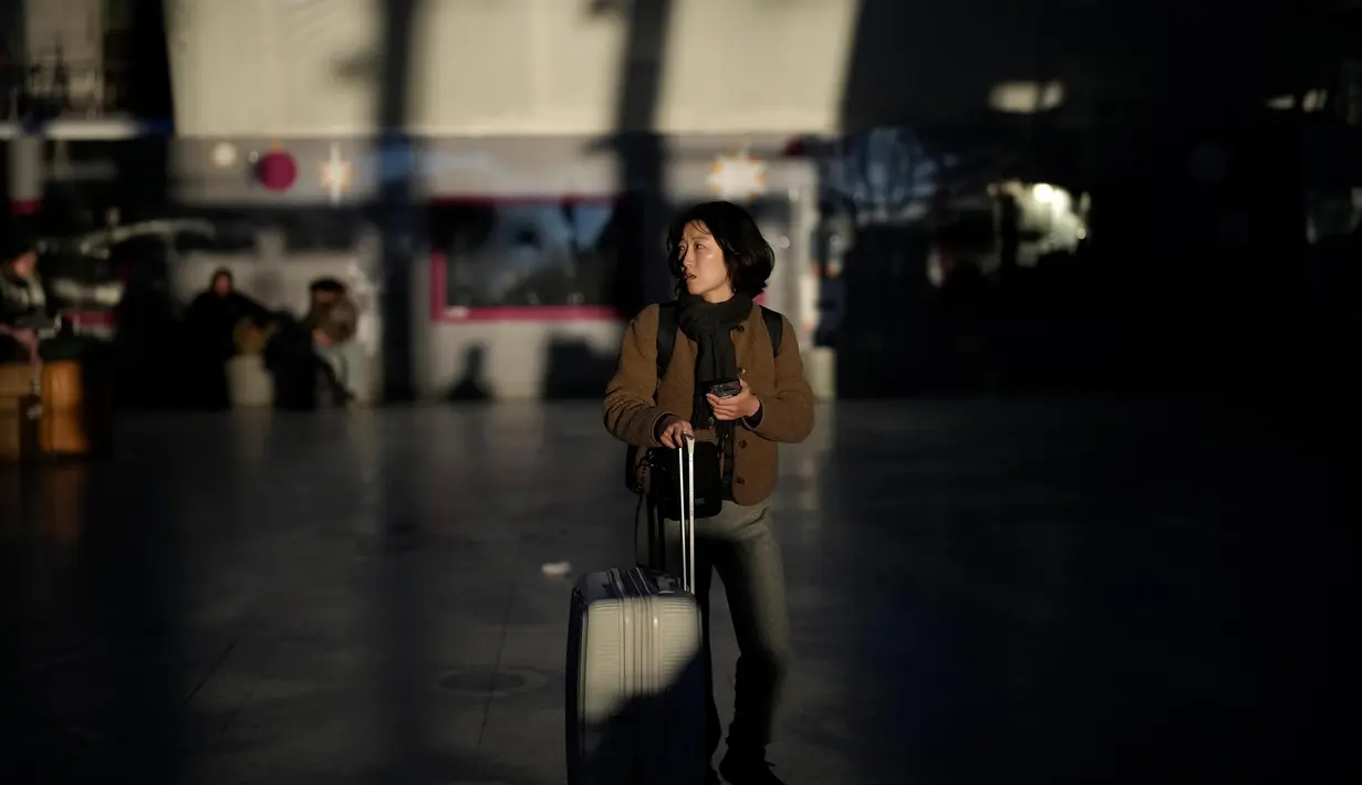 Calon penumpang menanti kedatangan kereta di stasiun Gare de Lyon Paris, Prancis, Selasa (7/2/2023). Parlemen Prancis telah mulai membahas dan memperdebatkan proposal reformasi pensiun yang tidak populer dari Presiden Emmanuel Macron terkait penundaan usia pensiun yang memicu pemogokan dan demonstrasi besar-besaran dalam beberapa pekan terakhir. (AP Photo/Christophe Ena)
