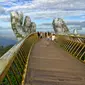 Pengunjung berjalan di sepanjang Golden Bridge di Perbukitan Ba Na dekat Danang, Vietnam, Selasa (31/7). Golden Bridge telah menarik banyak wisatawan sejak dibuka pada Juni 2018. (Linh PHAM/AFP)