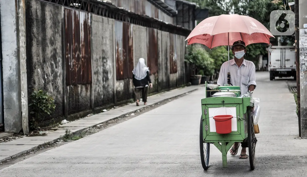 Pedagang kaki lima berkeliling di kawasan zona merah COVID-19 di RW 07 Kelurahan Sunter Jaya, Jakarta, Rabu (10/2/2021). Pemprov DKI Jakarta mencatat wilayah zona merah COVID-19 melonjak jadi 82 rukun warga (RW). (merdeka.com/Iqbal S. Nugroho)