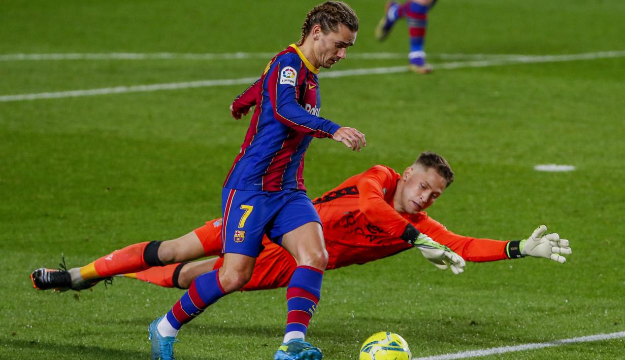 Penyerang Barcelona, Antoine Griezmann berusaha melewati kiper Real Sociedad, Alex Remiro  pada pertandingan La Liga Spanyol di stadion Camp Nou, Spanyol, Kamis (17/12/2020). Griezmann diboyong Barcelona dengan harga 120 juta euro dari Atletico Madrid. (AP Photo/Joan Monfort)