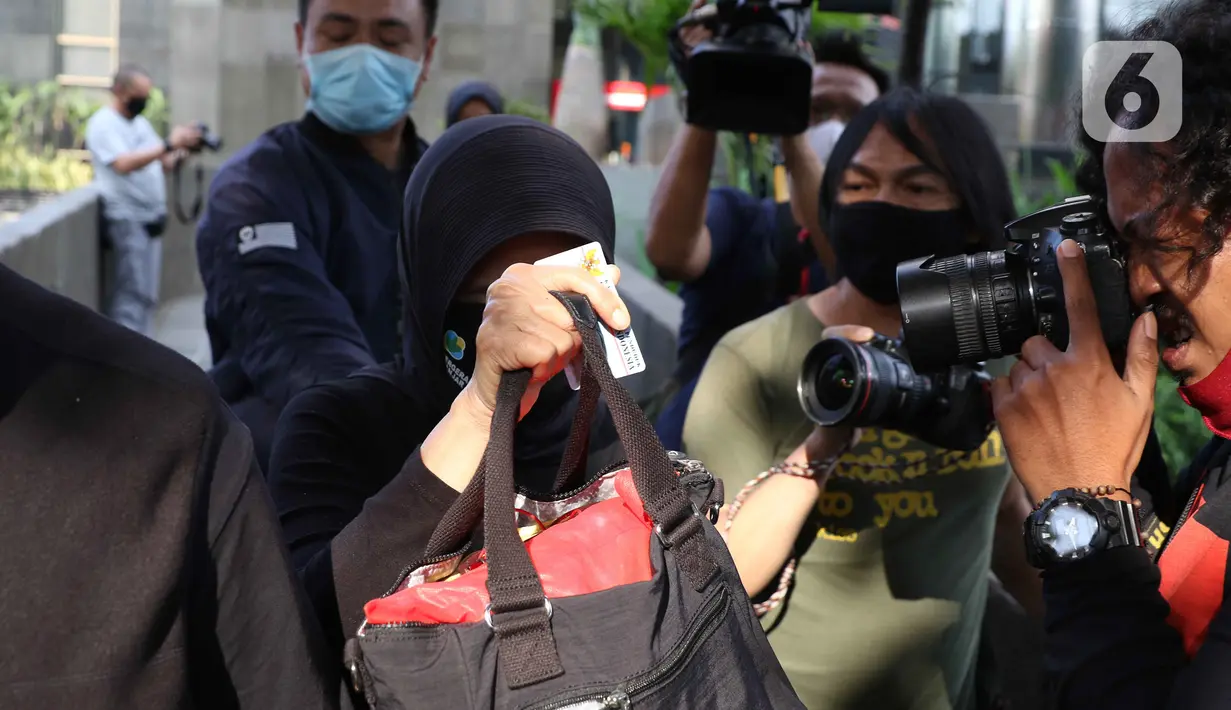 Wali Kota Banjar, Ade UU Sukaesih (tengah) menutupi wajah saat keluar area Gedung KPK, Jakarta, Rabu (12/8/2020). Ade UU Sukaesih diperiksa terkait proses penyidikan dugaan tindak pidana korupsi proyek infrastuktur pada dinas PUPR Kota Banjar TA 2012-2017. (Liputan6.com/Helmi Fithriansyah)