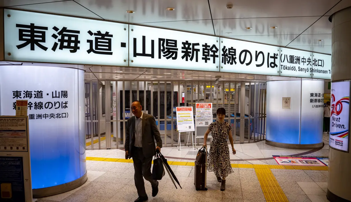 Orang-orang berjalan di depan gerbang tiket yang ditutup untuk Tokaido Shinkansen di Stasiun Tokyo pada 31 Agustus 2024. (Philip FONG/AFP)